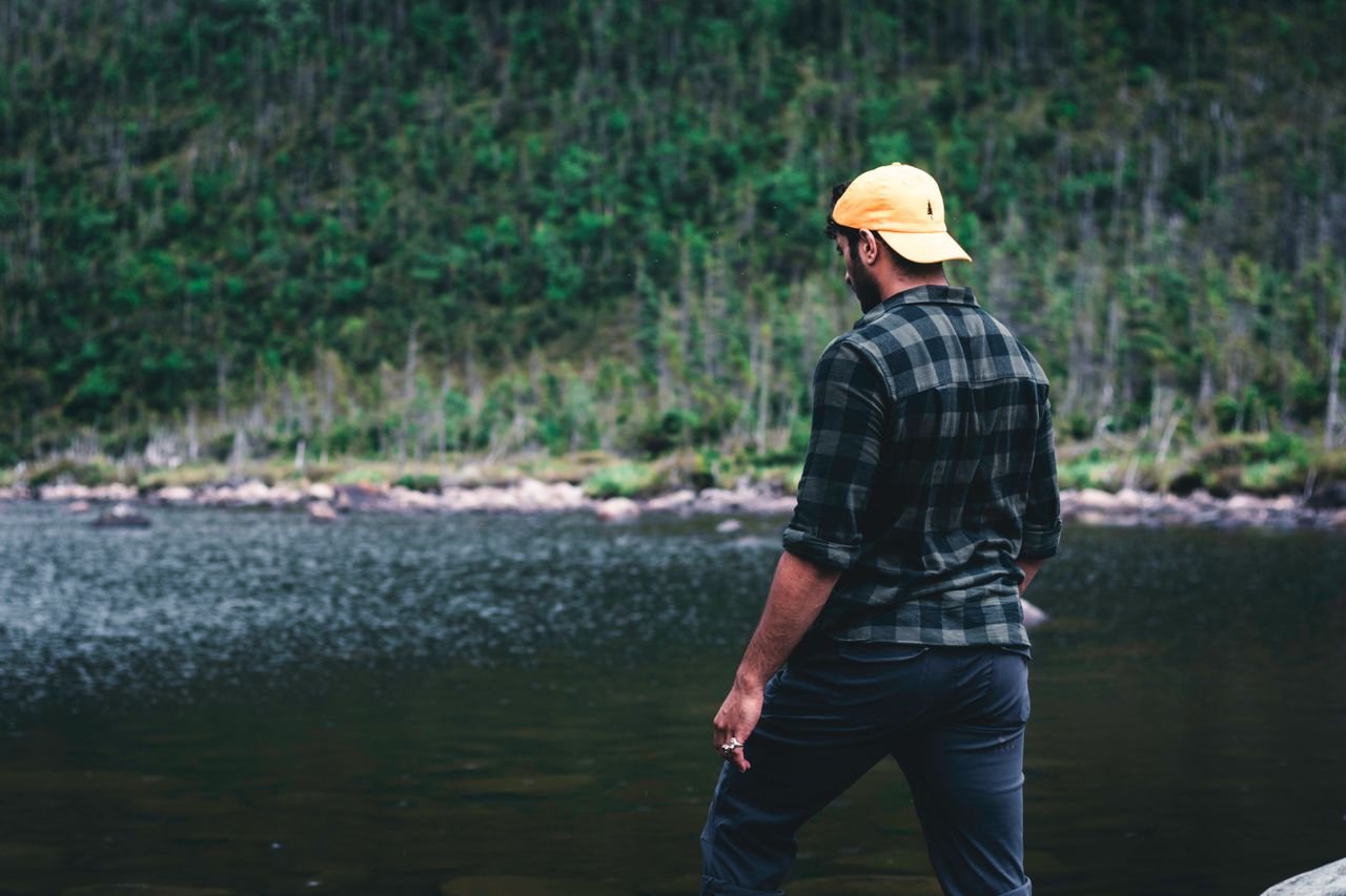 collection-04 A man wearing a cap hikes along the peaceful lake shores of Gaspé, Canada.